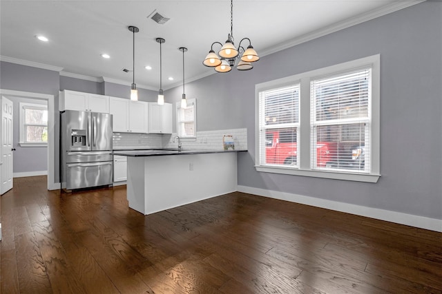 729 S Winnetka Ave, Dallas, TX 75208 - kitchen with stainless steel refrigerator with ice dispenser, a peninsula, a chandelier, white cabinets, and backsplash