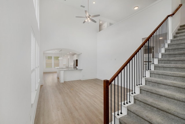 1721 Horseshoe Ln, Van Alstyne, TX 75495 - staircase with a ceiling fan, arched walkways, wood finished floors, a towering ceiling, and recessed lighting