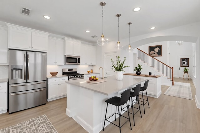 1721 Horseshoe Ln, Van Alstyne, TX 75495 - kitchen with appliances with stainless steel finishes, light wood finished floors, light countertops, white cabinetry, and recessed lighting