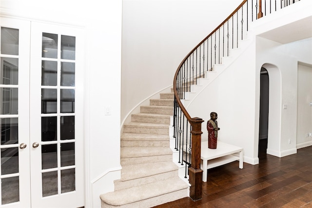 6925 Mercy Rd, Frisco, TX 75035 - stairway with wood-type flooring, arched walkways, baseboards, and french doors