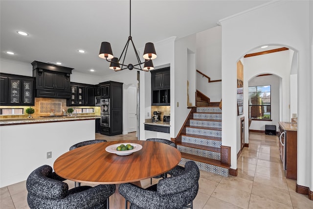 10388 Tobias Ln, Frisco, TX 75033 - dining space featuring crown molding, arched walkways, light tile patterned floors, a chandelier, and stairway