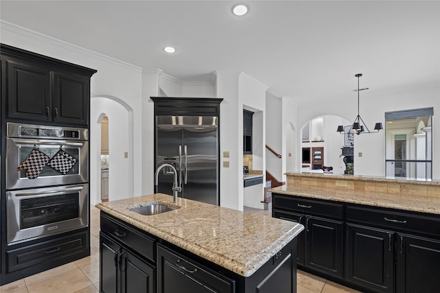 10388 Tobias Ln, Frisco, TX 75033 - kitchen featuring arched walkways, dark cabinets, stainless steel appliances, recessed lighting, and crown molding