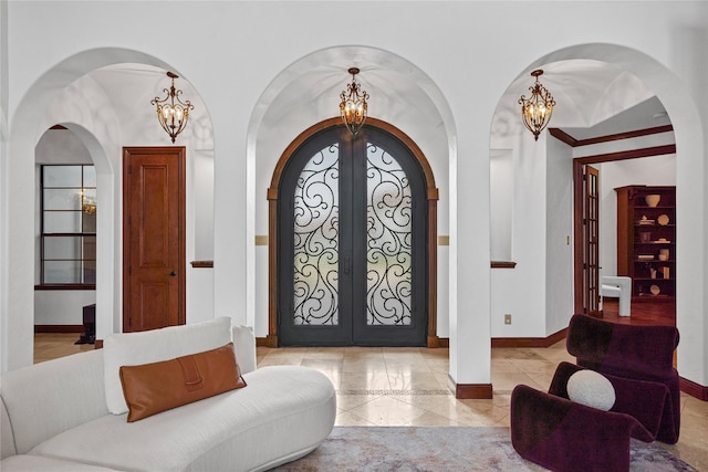 10388 Tobias Ln, Frisco, TX 75033 - entrance foyer with arched walkways, french doors, a chandelier, baseboards, and light tile patterned floors