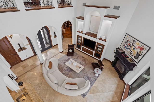 10388 Tobias Ln, Frisco, TX 75033 - living room with arched walkways, a high ceiling, and baseboards