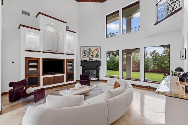 10388 Tobias Ln, Frisco, TX 75033 - living area with a high ceiling, light tile patterned floors, a glass covered fireplace, and baseboards