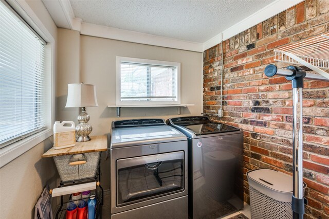 3601 Scranton Dr, Richland Hills, TX 76118 - washroom featuring separate washer and dryer, a textured ceiling, and brick wall