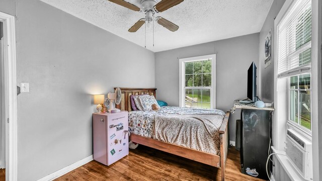 1007 SE 24th St, Mineral Wells, TX 76067 - bedroom featuring wood finished floors, a textured ceiling, baseboards, and ceiling fan