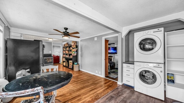 1007 SE 24th St, Mineral Wells, TX 76067 - laundry area featuring stacked washing machine and dryer, ceiling fan, dark wood-style flooring, a textured ceiling, and baseboards