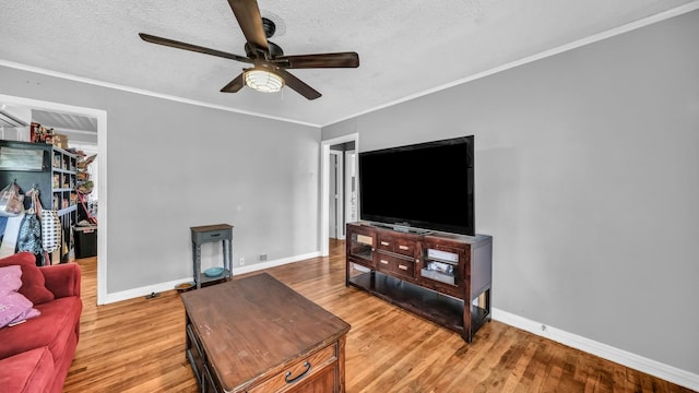 1007 SE 24th St, Mineral Wells, TX 76067 - living room with ceiling fan, baseboards, light wood-style flooring, ornamental molding, and a textured ceiling