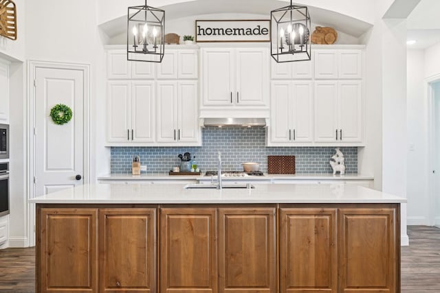 2816 Middleton Dr, Melissa, TX 75454 - kitchen with a chandelier, dark wood-type flooring, backsplash, and light countertops