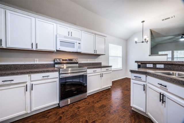 3901 Luck Hole Dr, Denton, TX 76210 - kitchen with white microwave, stainless steel electric range oven, lofted ceiling, dark countertops, and dark wood-style flooring