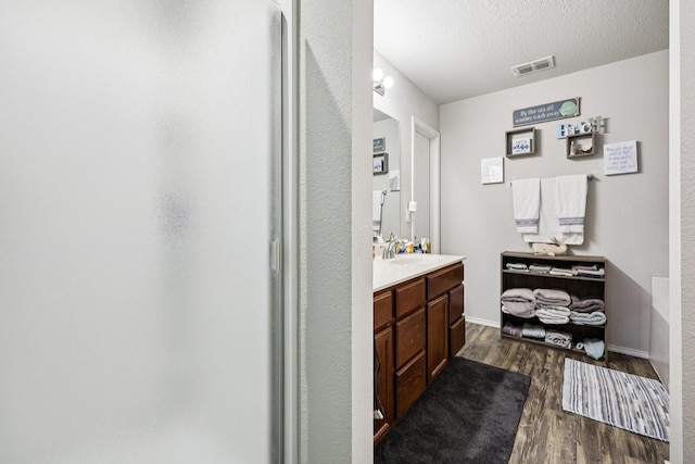 147 Cantle, Waxahachie, TX 75165 - full bath with vanity, wood finished floors, a walk in shower, and a textured ceiling