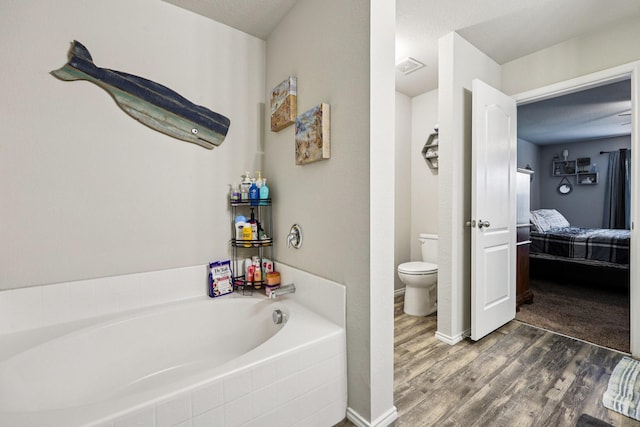 147 Cantle, Waxahachie, TX 75165 - ensuite bathroom featuring a bath, toilet, and wood finished floors