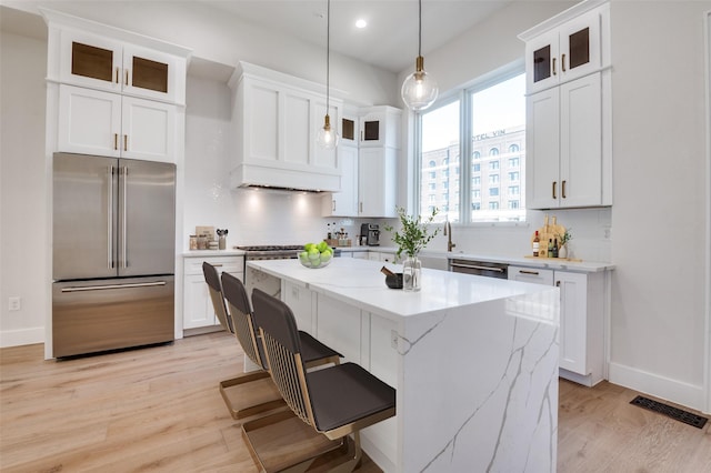235 E Nash St Unit 124, Grapevine, TX 76051 - kitchen with stainless steel appliances, backsplash, a center island, light wood-style floors, and recessed lighting