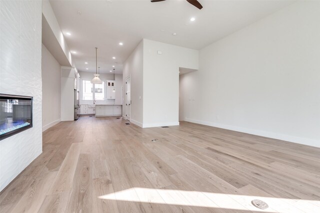 235 E Nash St Unit 124, Grapevine, TX 76051 - unfurnished living room with ceiling fan, a fireplace, recessed lighting, baseboards, and light wood finished floors