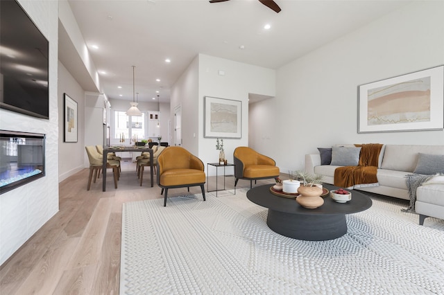 235 E Nash St Unit 124, Grapevine, TX 76051 - living area featuring light wood-type flooring, recessed lighting, a ceiling fan, a glass covered fireplace, and baseboards