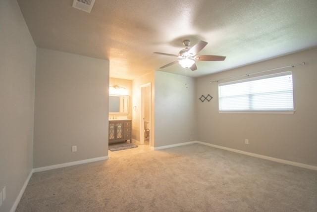 301 Patricia St, Lacy Lakeview, TX 76705 - unfurnished bedroom featuring carpet flooring, baseboards, ensuite bathroom, and a ceiling fan