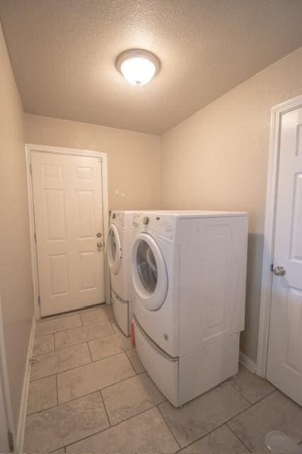 301 Patricia St, Lacy Lakeview, TX 76705 - laundry room featuring washer and dryer, a textured ceiling, baseboards, and light tile patterned floors