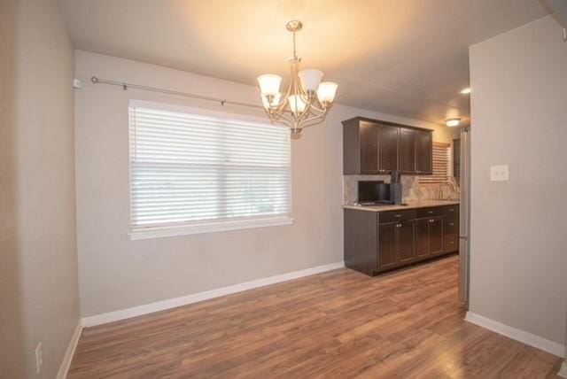 301 Patricia St, Lacy Lakeview, TX 76705 - kitchen featuring dark brown cabinetry, a chandelier, baseboards, light wood-style floors, and hanging light fixtures