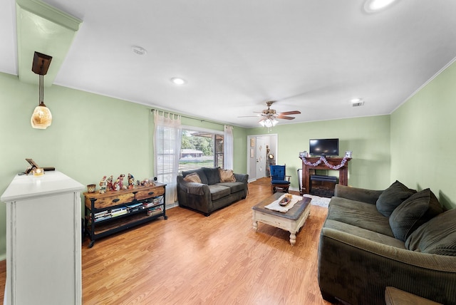 808 S Main St, Winnsboro, TX 75494 - living area featuring light wood-style floors, ornamental molding, a ceiling fan, a fireplace with flush hearth, and recessed lighting