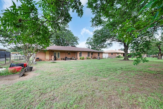 808 S Main St, Winnsboro, TX 75494 - back of property featuring brick siding, a patio, and a garden