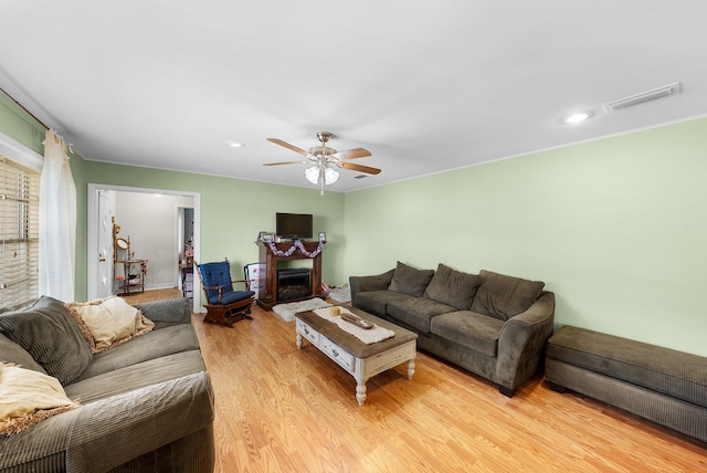 808 S Main St, Winnsboro, TX 75494 - living area with light wood-type flooring, ceiling fan, a fireplace with raised hearth, and recessed lighting