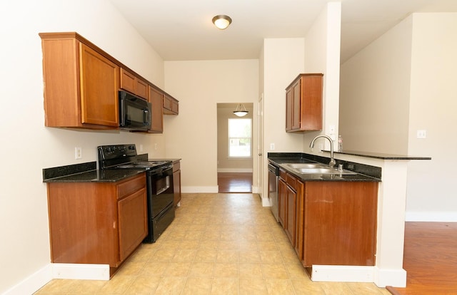 1634 Palm Beach Ave, Dallas, TX 75217 - kitchen featuring black appliances, a sink, a peninsula, baseboards, and dark stone countertops