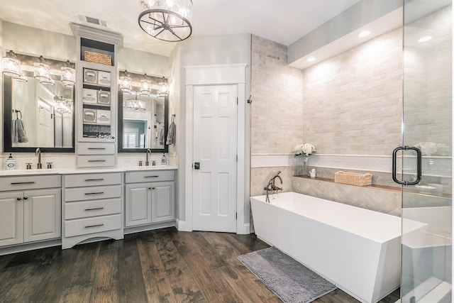 200 Sabine Creek Rd, Royse City, TX 75189 - bathroom with a freestanding tub, double vanity, wood finished floors, a chandelier, and recessed lighting