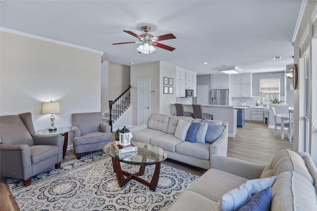 2904 Coventry Ln, Mckinney, TX 75069 - living room featuring a ceiling fan, light wood finished floors, stairs, recessed lighting, and ornamental molding