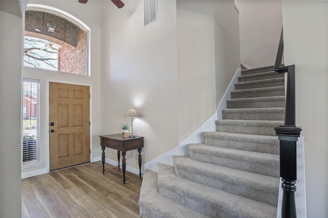 2904 Coventry Ln, Mckinney, TX 75069 - entryway featuring stairs, a high ceiling, a ceiling fan, wood finished floors, and baseboards