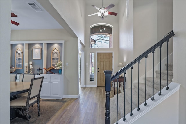 2904 Coventry Ln, Mckinney, TX 75069 - foyer entrance featuring a ceiling fan, a high ceiling, wood finished floors, stairs, and baseboards