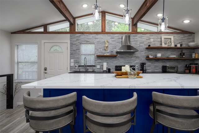 207 Wales Dr, Pottsboro, TX 75076 - kitchen with wall chimney range hood, open shelves, light wood finished floors, light stone countertops, and recessed lighting