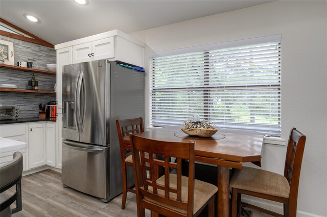 207 Wales Dr, Pottsboro, TX 75076 - kitchen featuring stainless steel fridge, tasteful backsplash, white cabinetry, lofted ceiling, and light wood-style floors