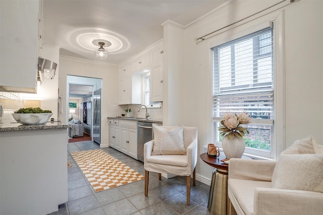 3201 Lamesa Pl, Fort Worth, TX 76109 - kitchen with stainless steel appliances, backsplash, white cabinets, a sink, and crown molding