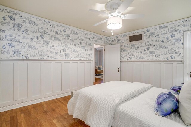 3201 Lamesa Pl, Fort Worth, TX 76109 - bedroom featuring wainscoting, light wood-type flooring, wallpapered walls, and ceiling fan
