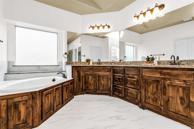 4312 Oxbow Dr, Mckinney, TX 75072 - bathroom with double vanity, a bath, and marble look tile flooring