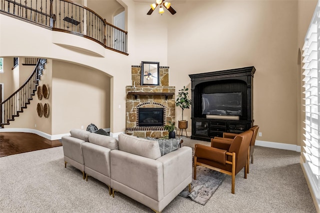 4312 Oxbow Dr, Mckinney, TX 75072 - carpeted living area featuring a high ceiling, a fireplace, a ceiling fan, baseboards, and stairs