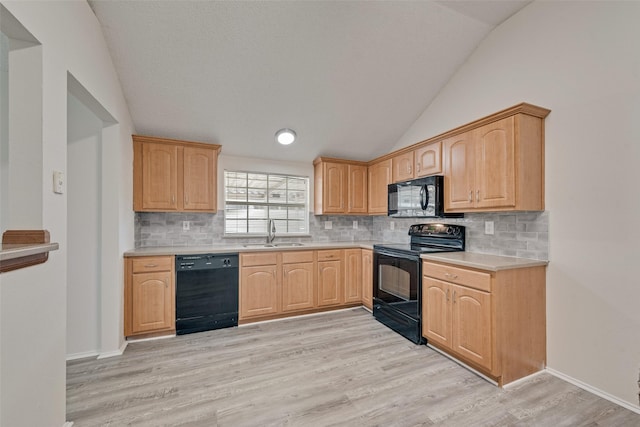 1326 Rosewood Ln, Lancaster, TX 75146 - kitchen featuring black appliances, a sink, vaulted ceiling, light countertops, and light wood-type flooring