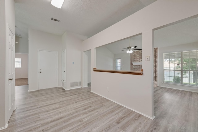 1326 Rosewood Ln, Lancaster, TX 75146 - spare room featuring ceiling fan, vaulted ceiling, light wood-style flooring, baseboards, and a textured ceiling