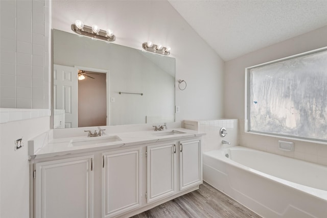 1326 Rosewood Ln, Lancaster, TX 75146 - full bath with lofted ceiling, a garden tub, double vanity, wood finished floors, and a ceiling fan