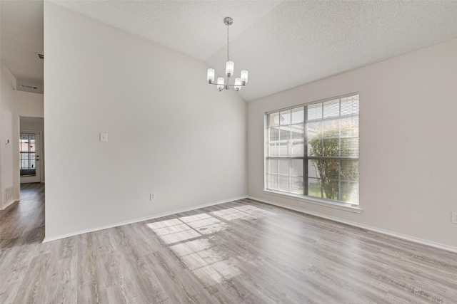 1326 Rosewood Ln, Lancaster, TX 75146 - unfurnished room with healthy amount of natural light, a chandelier, wood finished floors, vaulted ceiling, and baseboards