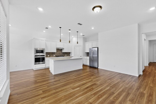3804 Honeycomb Holw, Melissa, TX 75454 - kitchen with stainless steel appliances, light countertops, open floor plan, decorative backsplash, and light wood-type flooring