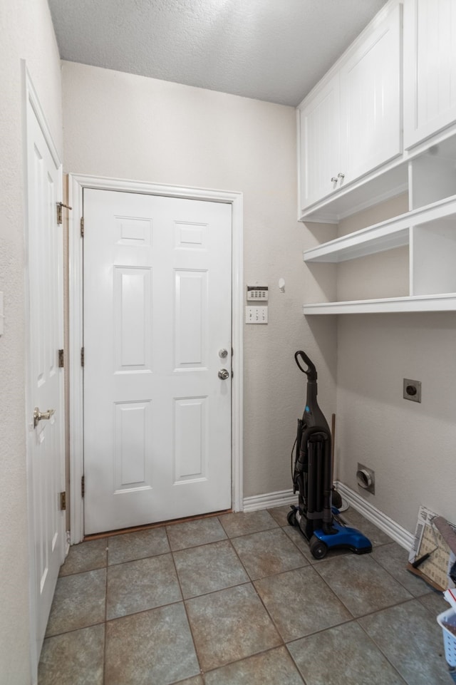 504 Hilltop Pl, Joshua, TX 76058 - washroom featuring cabinet space, electric dryer hookup, baseboards, and light tile patterned floors