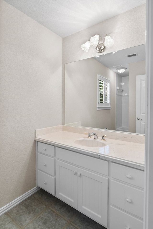 504 Hilltop Pl, Joshua, TX 76058 - bathroom featuring vanity, tile patterned floors, baseboards, a shower, and a textured wall