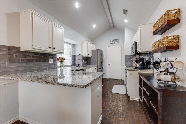 143 Westwood Dr, Rockwall, TX 75032 - kitchen with dark wood-style flooring, stainless steel appliances, light stone countertops, a sink, and a peninsula