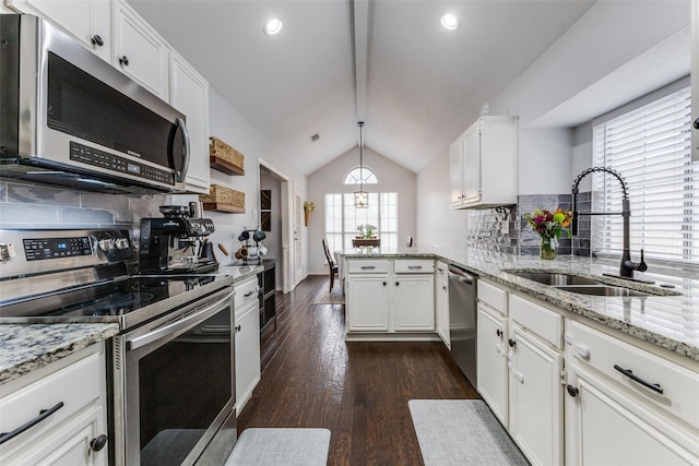143 Westwood Dr, Rockwall, TX 75032 - kitchen with appliances with stainless steel finishes, a sink, a peninsula, decorative backsplash, and dark wood finished floors