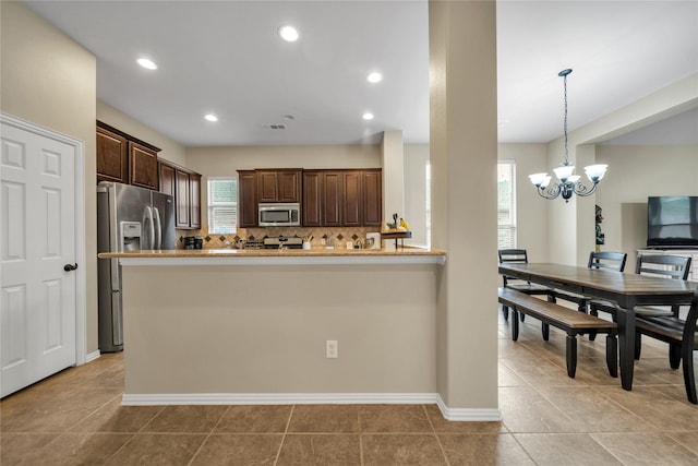 583 Louder Way, Fate, TX 75087 - kitchen featuring appliances with stainless steel finishes, plenty of natural light, dark brown cabinets, a chandelier, and recessed lighting