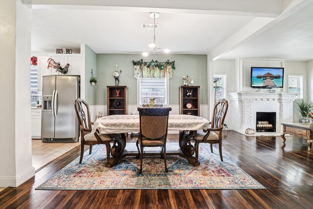 2704 Travis Ave, Fort Worth, TX 76110 - dining area featuring plenty of natural light, wood finished floors, a brick fireplace, and baseboards