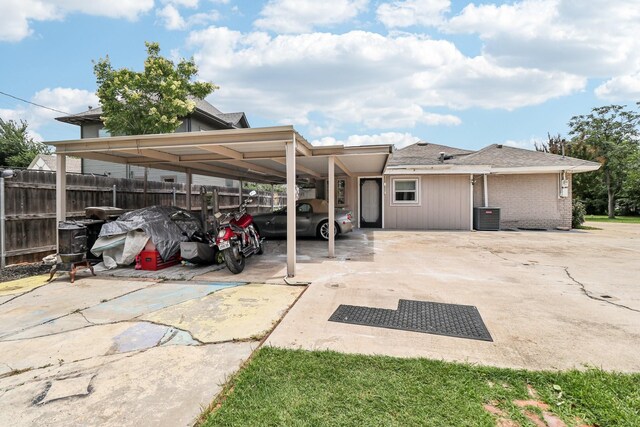 2704 Travis Ave, Fort Worth, TX 76110 - rear view of house featuring a carport, central AC, concrete driveway, and brick siding