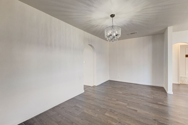 816 Northwood Rd, Fort Worth, TX 76107 - unfurnished room featuring arched walkways, a chandelier, dark wood finished floors, and baseboards